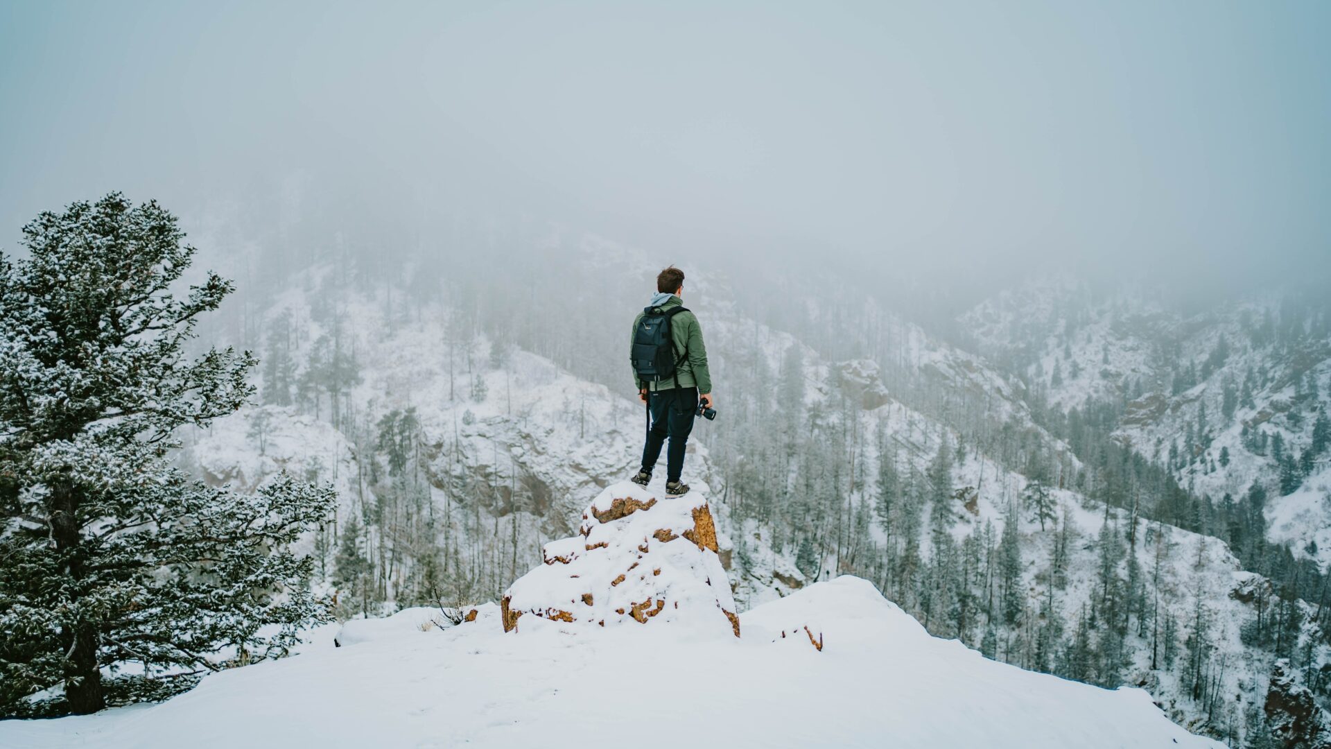 Man met camera in hand op besneeuwde bergen
